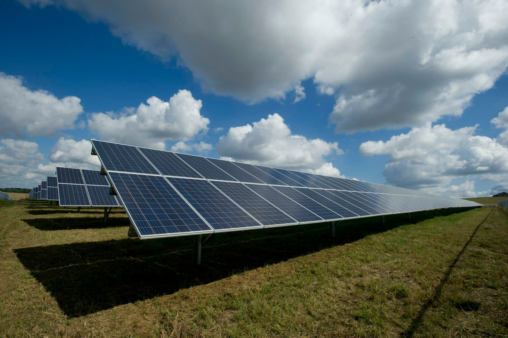 A utility-scale solar array under a bright sky